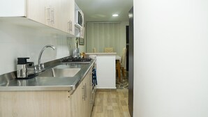 Una cocina con electrodomésticos de acero inoxidable, un fregadero y armarios de madera.