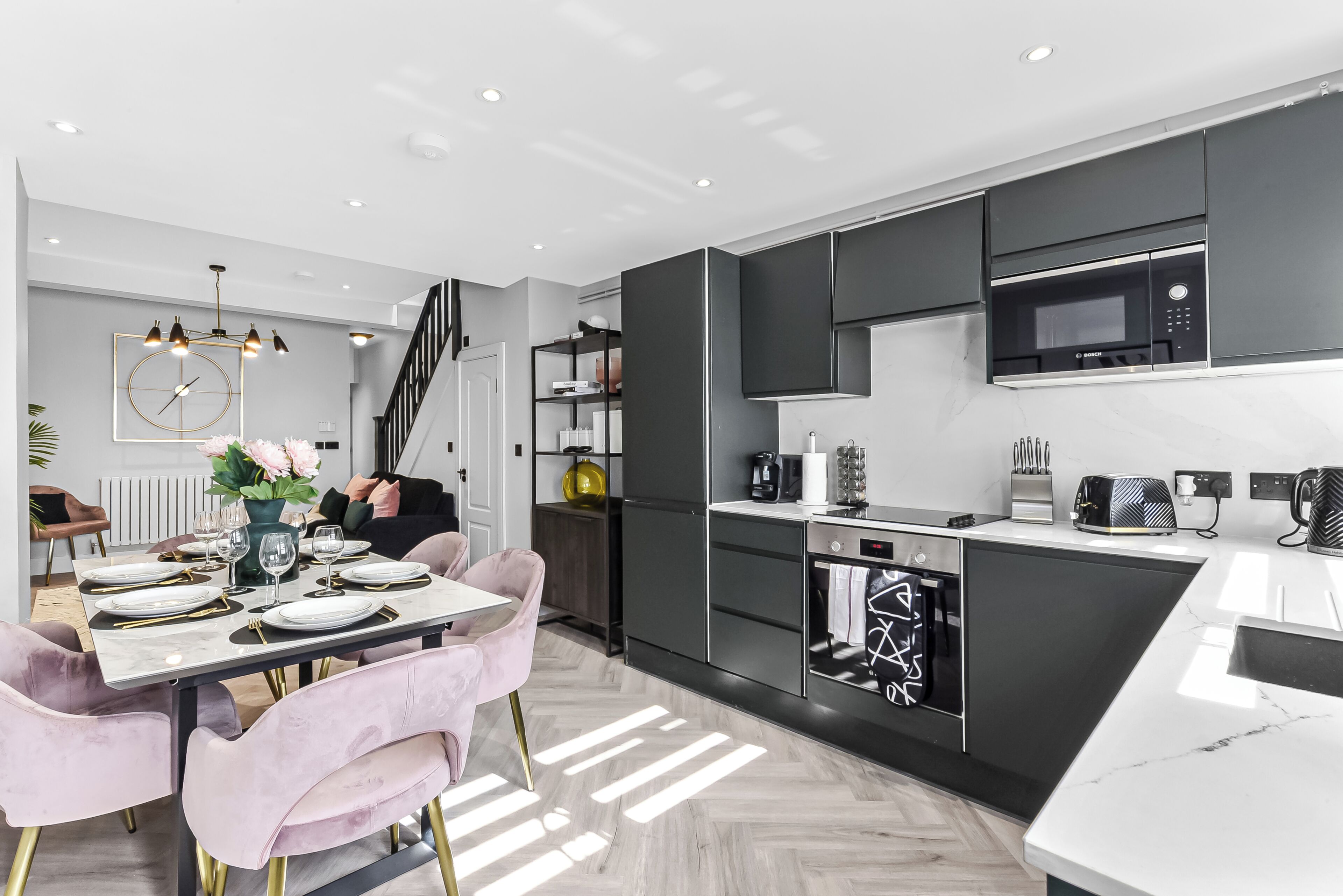 A modern kitchen with black cabinets, a microwave, and a coffee maker.