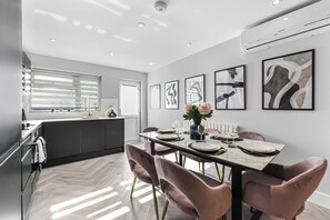 A modern kitchen with a dining area. - The Ultimate Hangout 4BR Modern House with Garden (Enfield)