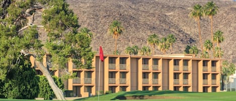 A hotel with a flat roof, multiple balconies, and a flagpole.