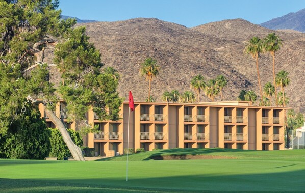 A hotel with a flat roof, multiple balconies, and a flagpole.