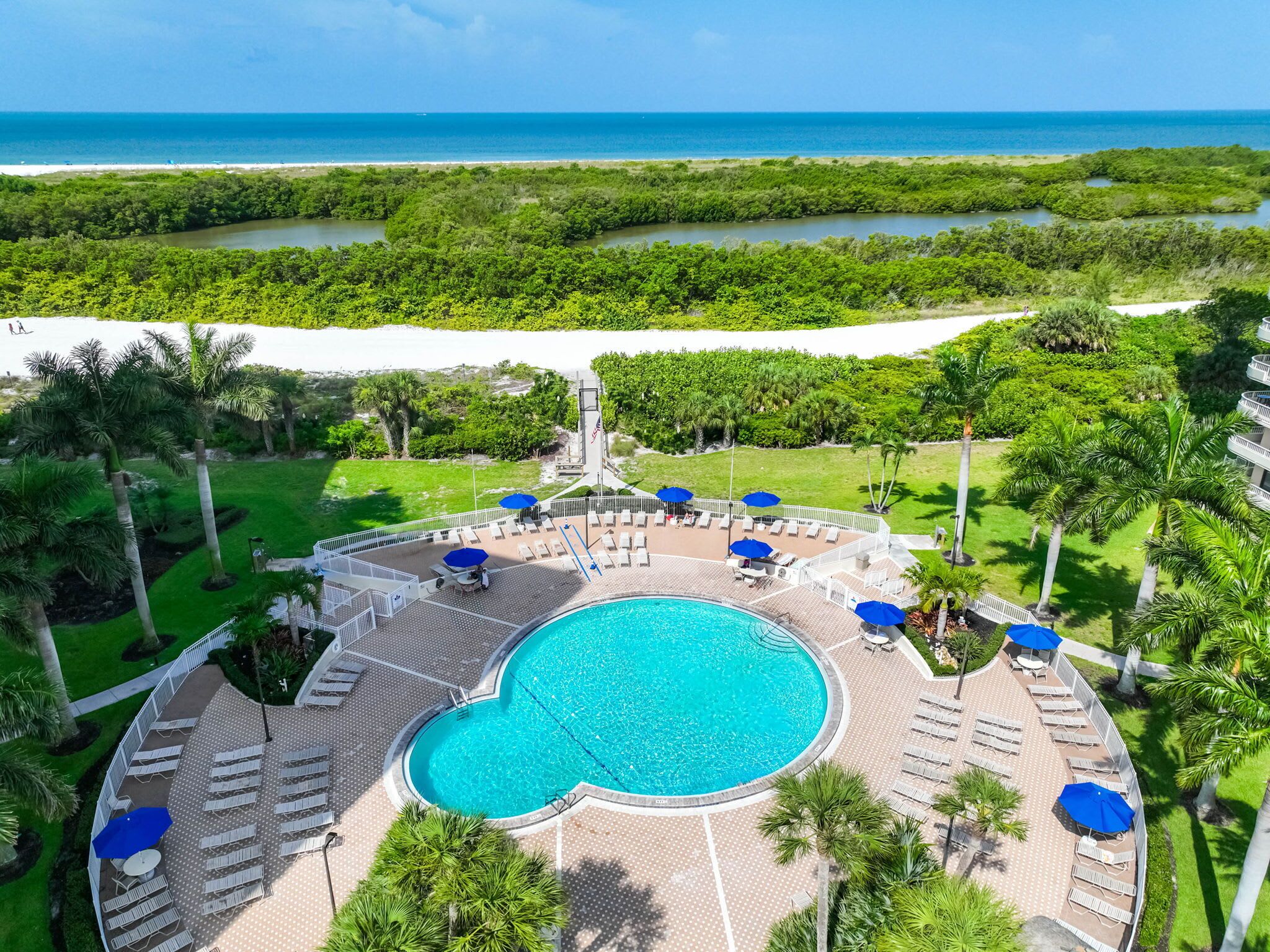 Ein Resort mit großem Pool, Liegebereichen und Blick auf den Ozean.