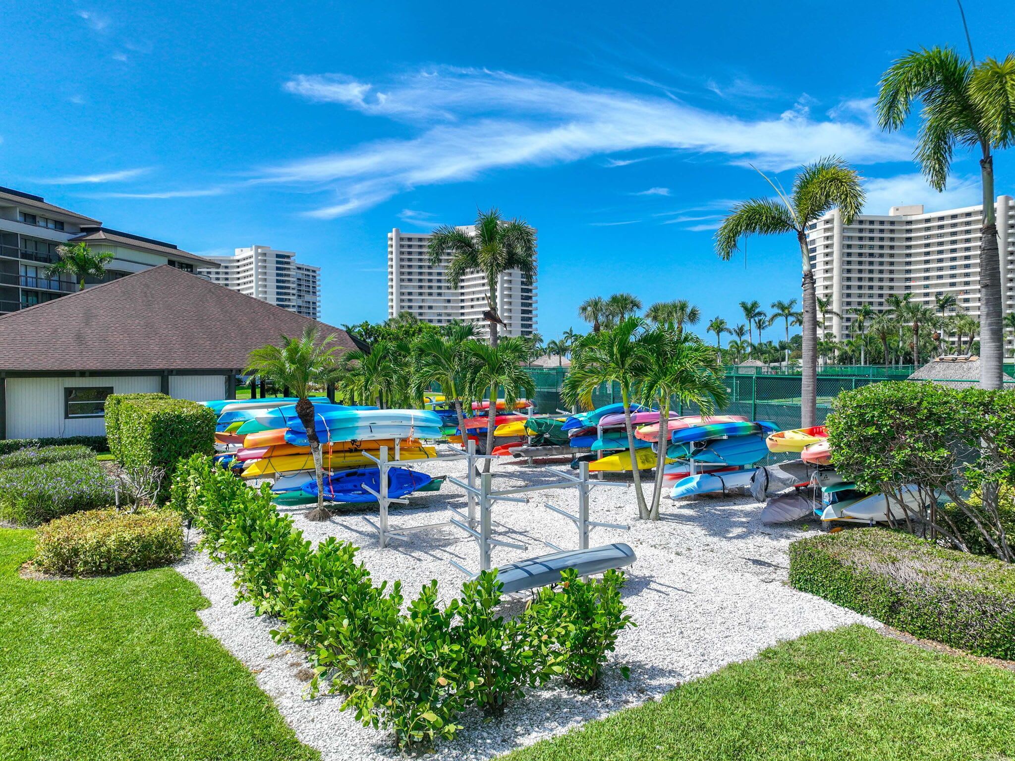Una marina con varios kayaks de colores y un pequeño edificio.