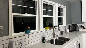 A kitchen with white cabinetry, a double sink, and a window with a view. - Beautiful Lake House Minutes from Lake Oroville (Oroville)
