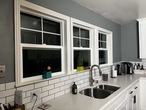 Eine Küche mit weißen Schränken, einer doppelten Spüle und einem Fenster mit Blick.