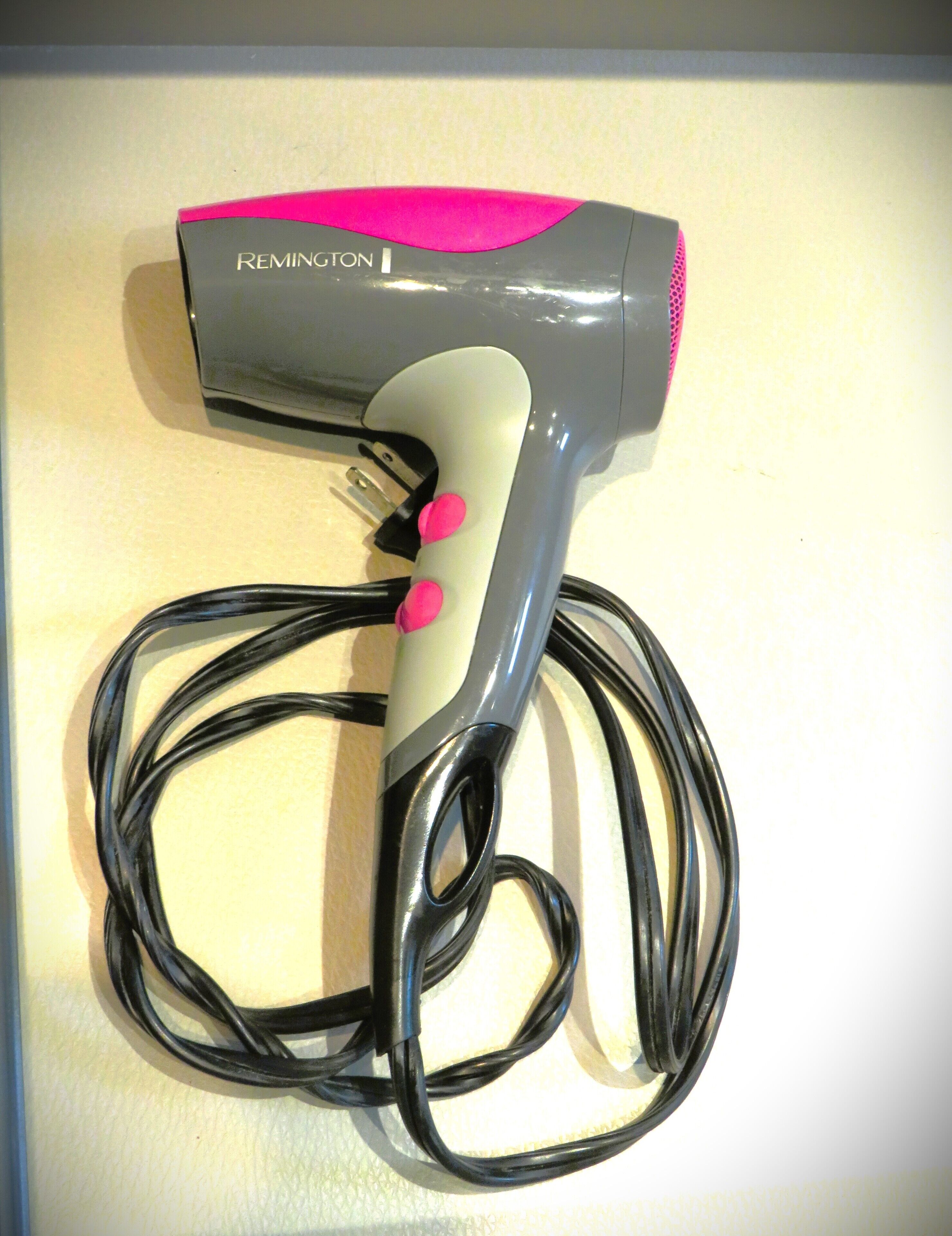 Un secador de pelo Remington con cable.