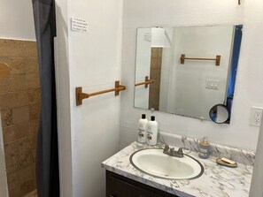 Un bany amb un lavabo, mirall i articles de tocador.