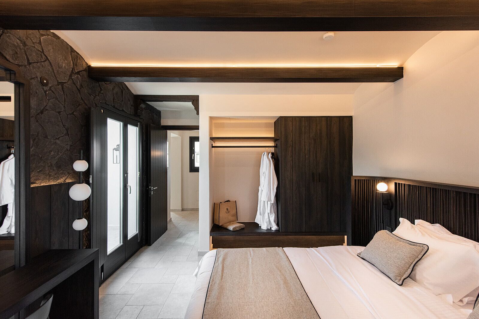 Ein modernes Schlafzimmer mit einem großen Bett, einem Kleiderschrank und einem begehbaren Kleiderschrank.