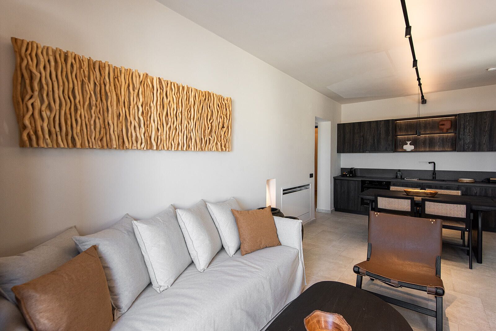A modern living room with a sofa, a coffee table, and a dining area with chairs and a table.