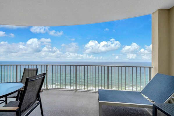 Ein Balkon mit Blick auf den Ozean, inklusive Tisch und zwei Stühlen.