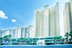 Ein mehrstöckiges Hotel mit zentralem Atrium, Tiefgarage und Palmen.