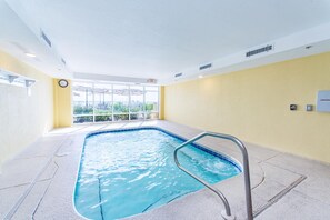 Ein Hallenbad mit freiem Blick ins Freie durch große Fenster.