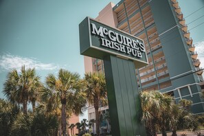 Ein Schild für das McGure's Irish Pub vor einem modernen Gebäude im Hintergrund.