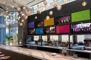A bar area with hanging spherical light fixtures, shelves of liquor bottles, and a marble countertop. - Comfy Condo-Hotel in Downtown Miami (Miami)