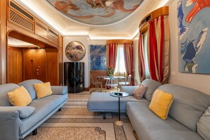 A spacious living area with a modern sofa set, a coffee table, and a dining table with chairs. - Spazio Santana (Milano)