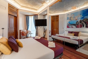 A hotel room with a large bed, a TV, a desk with a chair, and a painting on the wall. - Spazio Santana (Milano)