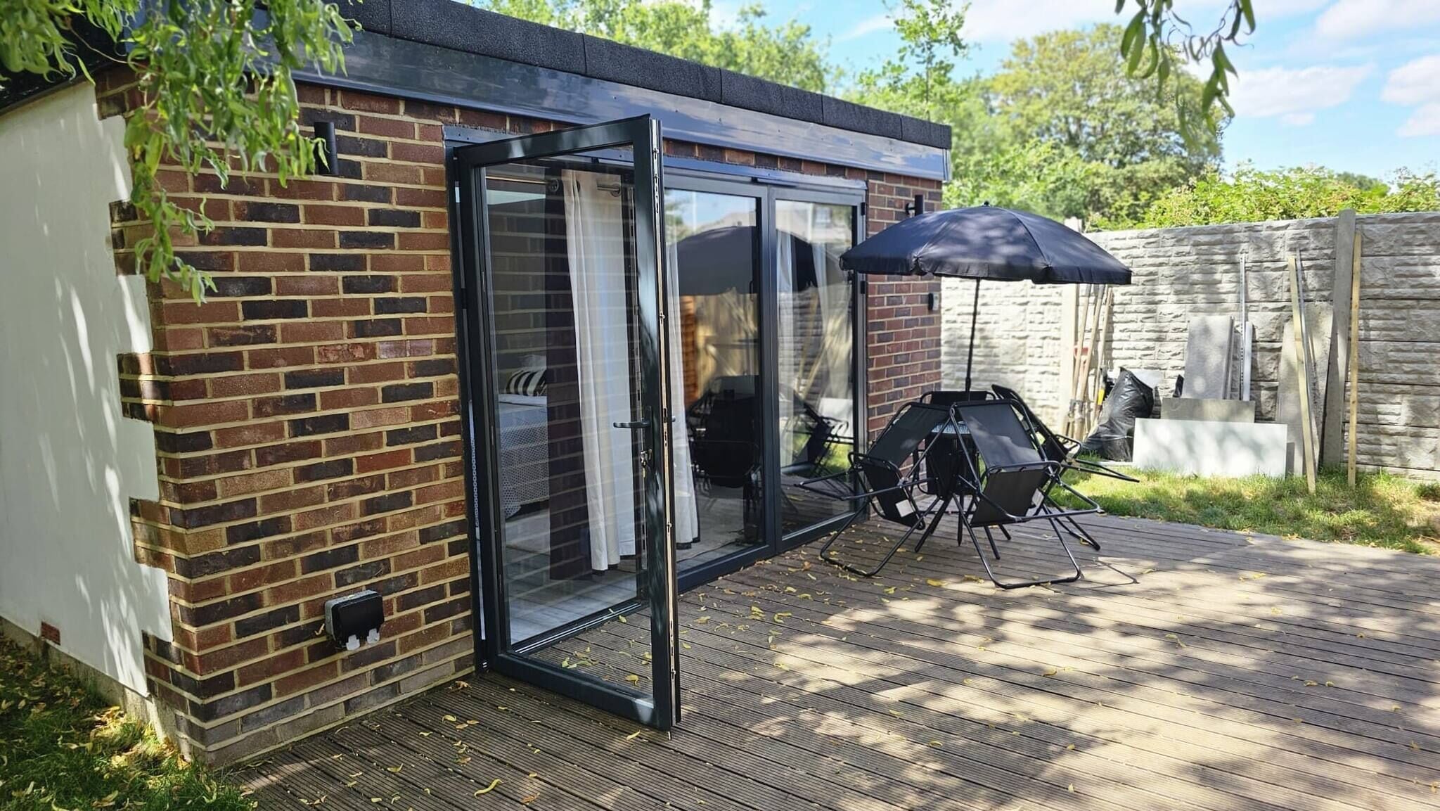 A brick house with a glass door leading to an outdoor patio.