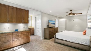 A bedroom with a bed, a dresser, a television, and a ceiling fan. - Wailea Ekahi 42C - Peekaboo Ocean Views, 2 Full Baths, King Tempurpedic, Full AC (Kihei)