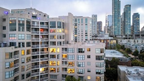 Ein mehrstöckiges Hotel mit Balkonen, einer Dachterrasse und einer Stadtkulisse im Hintergrund.