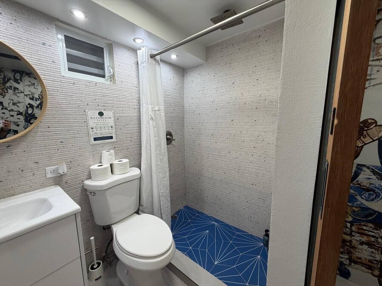 A bathroom with a toilet, sink, and shower.