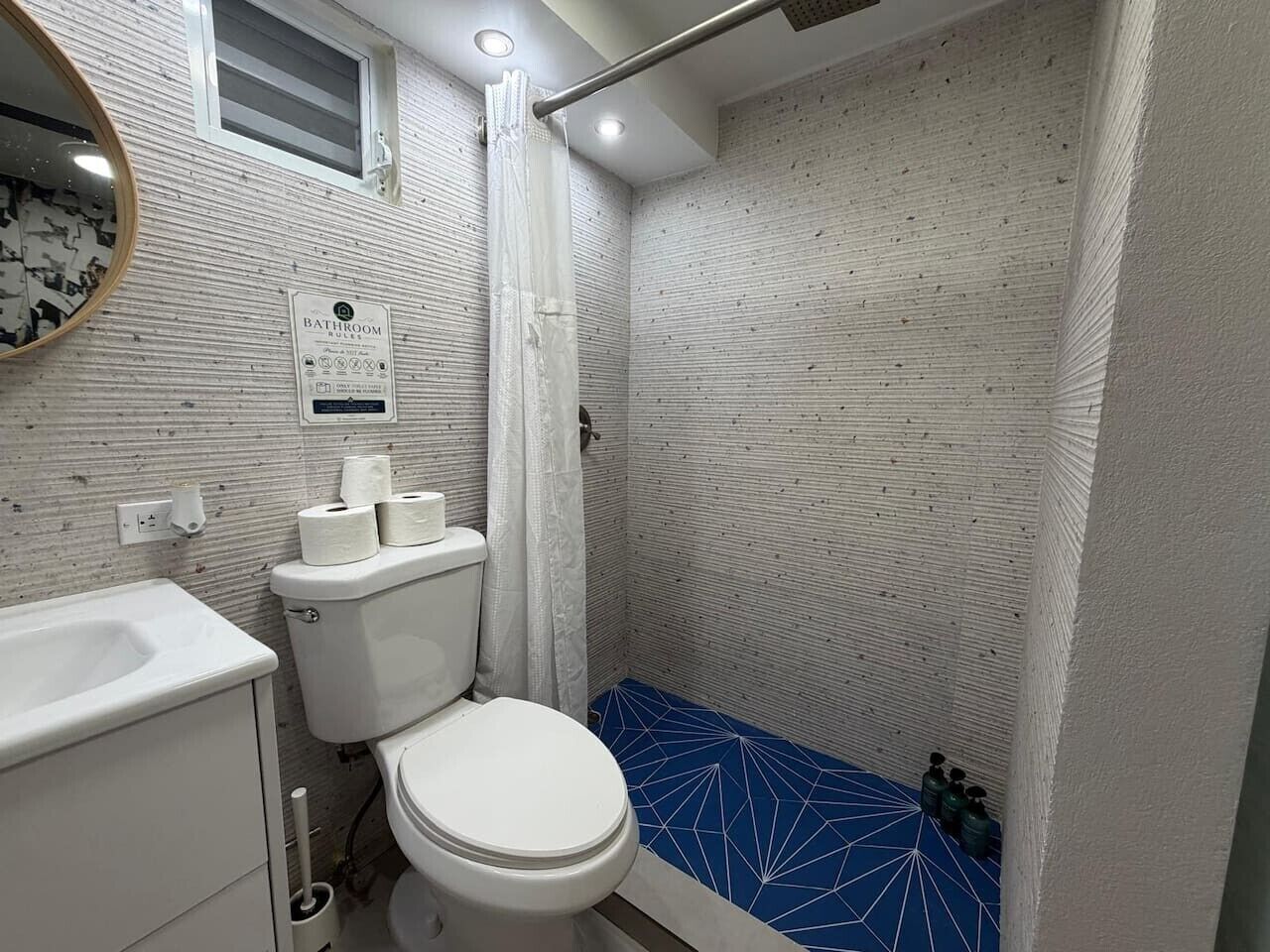 Een badkamer met toilet, wastafel en douche.