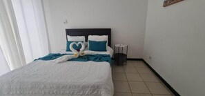 Ein Hotelzimmer mit einem Bett, einem Nachttisch und einer Wandleuchte.