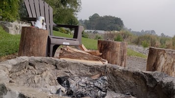 Un décor extérieur rustique composé d’une structure en bois, d’une chaise et d’une bûche.
