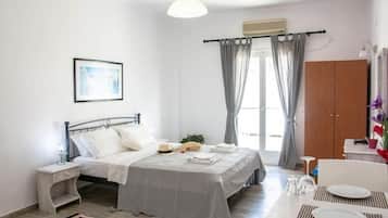 Un dormitorio con cama, mesita de noche y una zona de comedor con mesa y sillas.