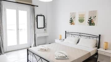 Una camera d'albergo con un letto, comodini, uno specchio e opere d'arte appese al muro.