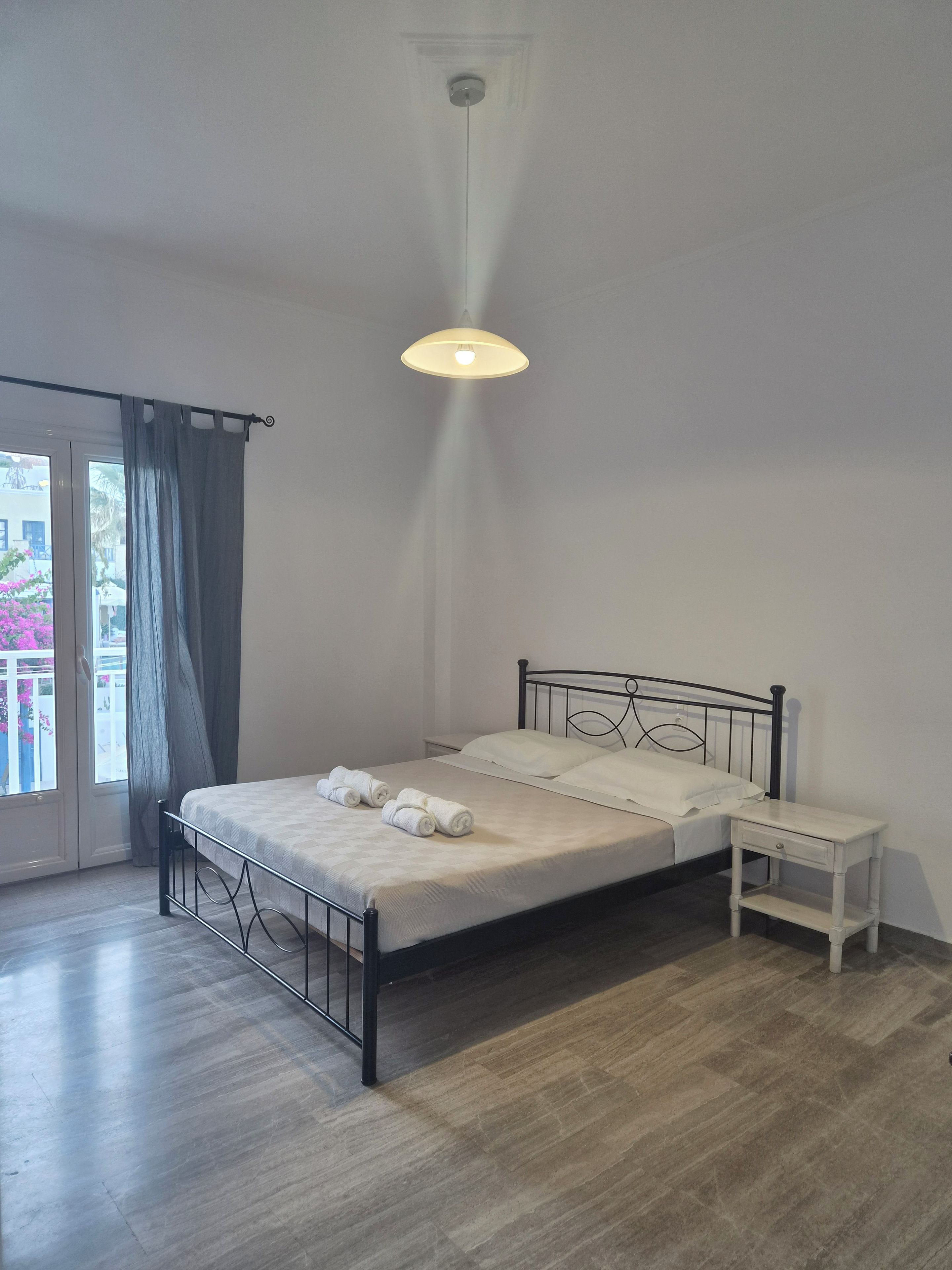 Una camera da letto con un letto, un comodino e vista dalla finestra.