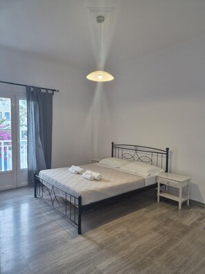Un dormitorio con cama, mesita de noche y vistas a través de una ventana.