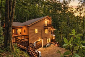 Eine zweistöckige Holzhütte mit einer Terrasse und einer Treppe, die zum Eingang führt.