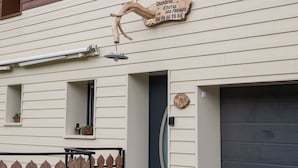 Un bâtiment avec une enseigne indiquant qu’il s’agit d’un hôtel, une porte de garage et une clôture en bois.