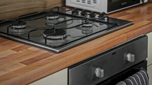 Eine Küche mit Gasherd, Mikrowelle und Backofen.