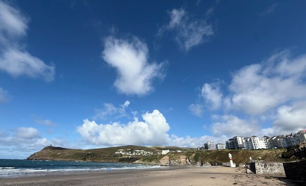 A coastal landscape with a beach, cliffs, and buildings.
