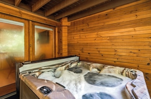 A wooden cabin interior with a hot tub. - Relax by the Waterfall*Hot Tub*Pet-Friendly (Sevierville)