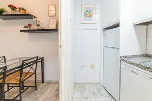 A kitchen with white cabinets, a granite countertop, and a built-in dishwasher. - Home2Book Sevilla Terrace & Pool Apt (Seville)