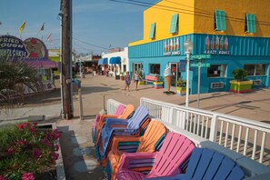 A street with colorful buildings, including a bakery and an ice cream shop. - Luxury Oceanfront Carolina Beach Condo w/ Private Beach Access. Full ocean view! (Carolina Beach)