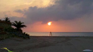 A beach with a chair facing the sunset. - Groundfloor Oasis Beach VII Punta Prima (Torrevieja)