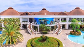 Ein Resort mit Innenhof, Schwimmbecken und einem Wandgemälde von einer Meeresschildkröte.