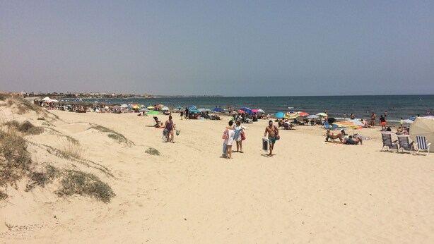 A beach with people, umbrellas, and beach chairs. - Penthouse Higuericas Playas (Pilar de la Horadada)