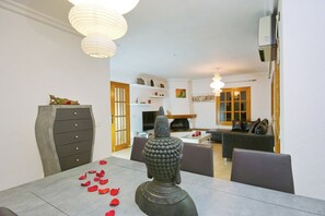 Ein Essbereich mit Buddha-Statue, einem Tisch mit Rosenblättern und modernem Interieur.
