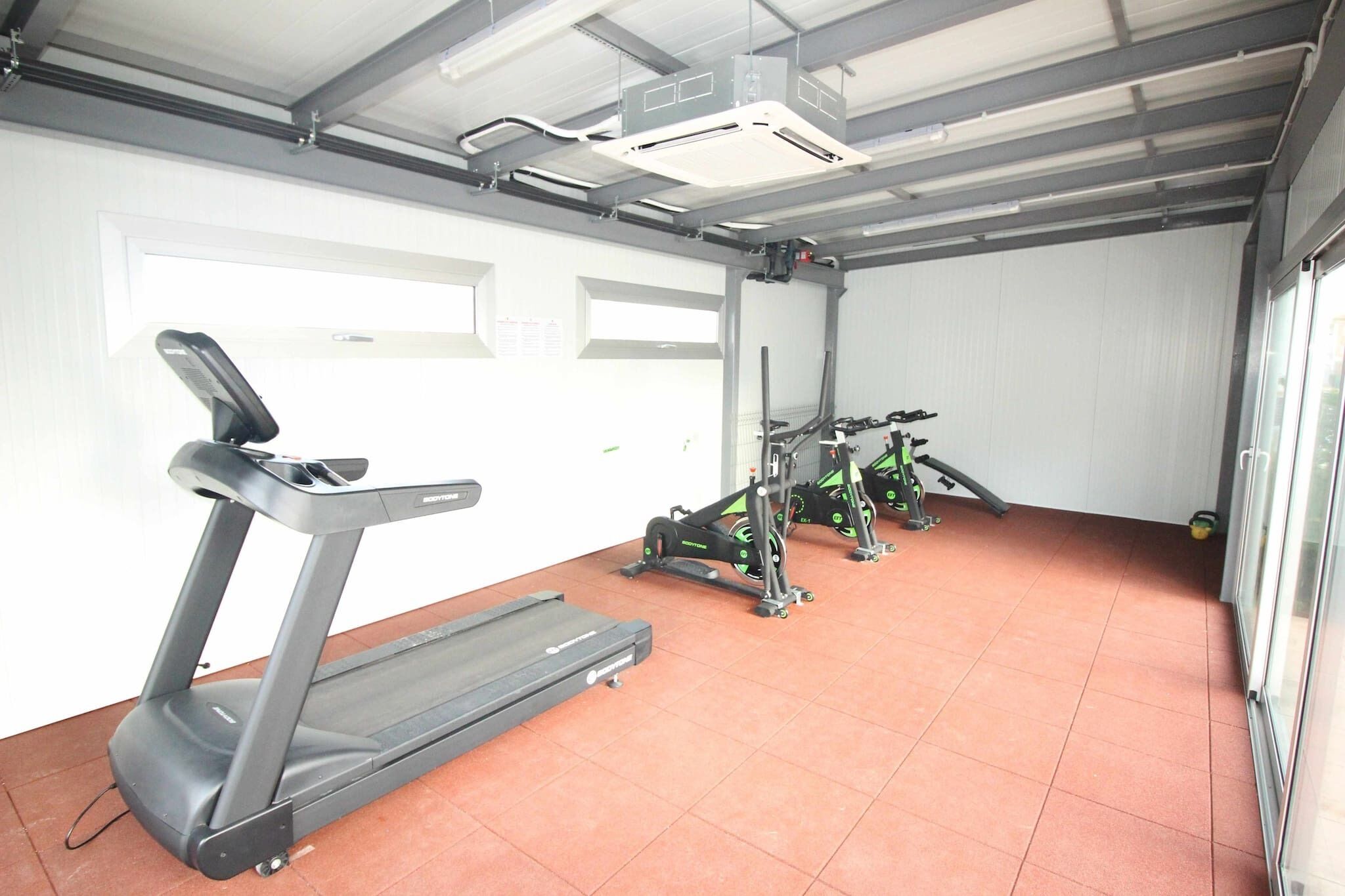 Une salle de sport équipée de tapis de course et d'appareils de musculation.