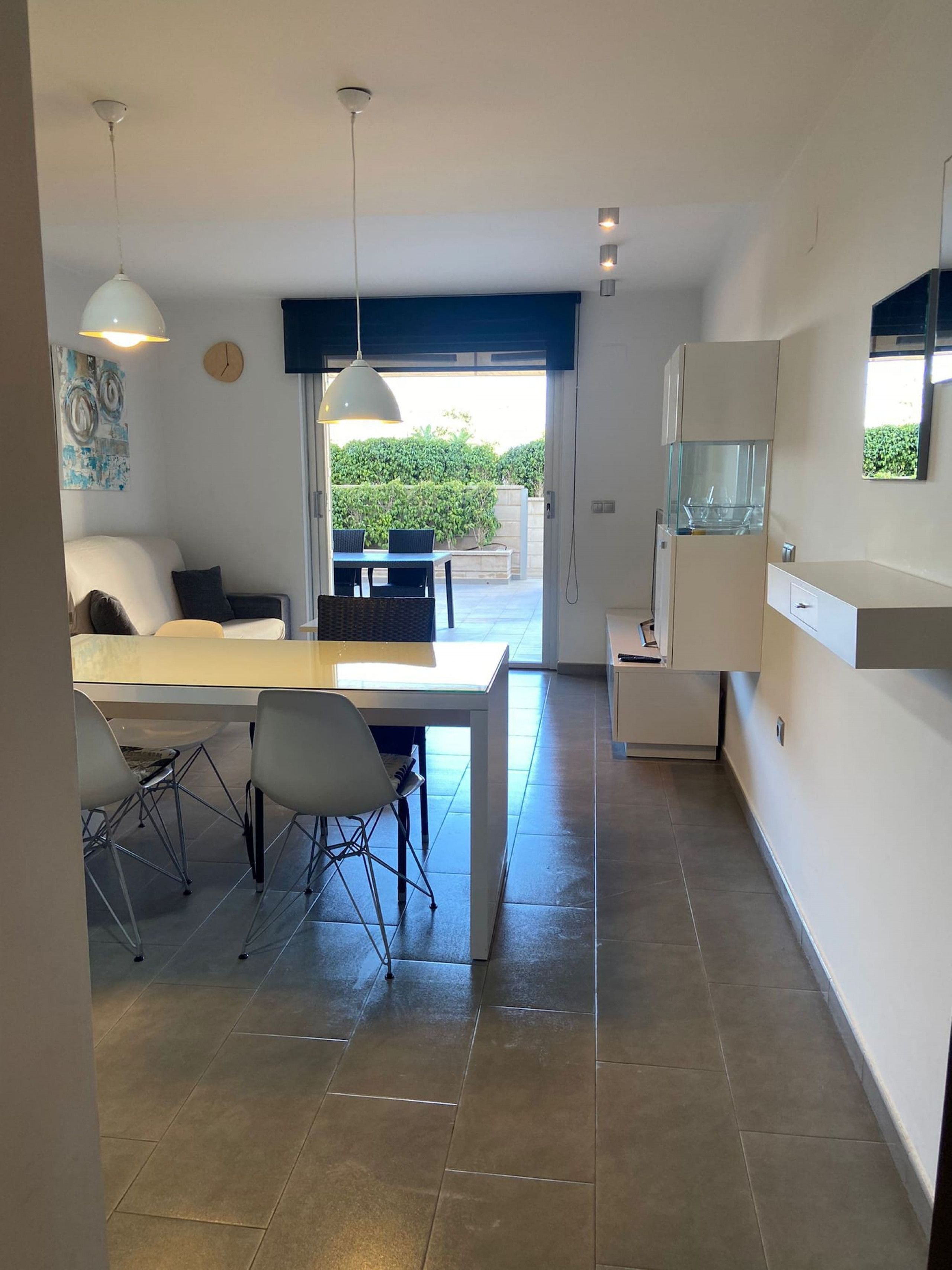 Una cucina moderna con zona pranzo, frigorifero integrato e vista sull'esterno.