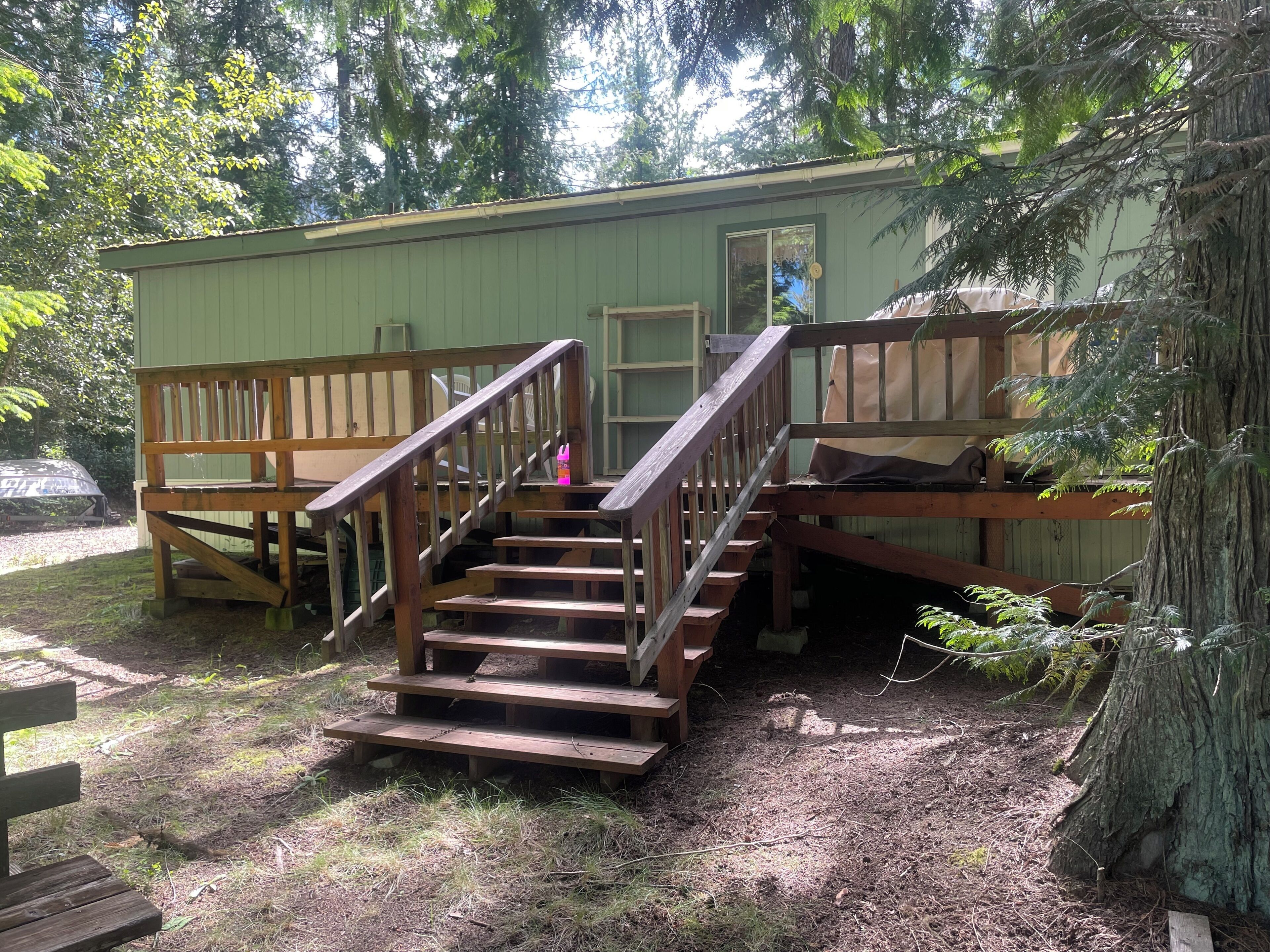 A wooden staircase leading to a cabin with a deck and a door.