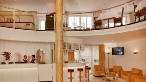 A hotel lobby with a reception desk, seating area, and a bar. - 2 Person Holiday Park Home in Stade (Stade)