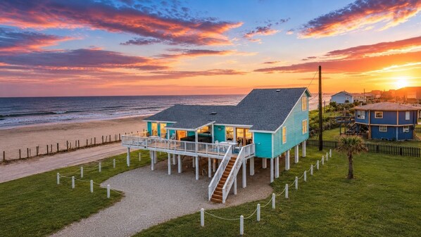 A beachfront house with a deck and stairs leading to the entrance. - Beachfront, Hot Tub, Arcade, Foosball, Steps to beach, outdoor games & MORE (Galveston)