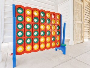 A colorful board game setup with a grid of holes, blue stands, and a wooden door in the background. - Beachfront, Hot Tub, Arcade, Foosball, Steps to beach, outdoor games & MORE (Galveston)