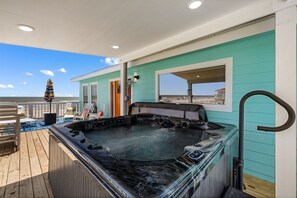 A hot tub on a wooden deck with a view of the beach and ocean. - Beachfront, Hot Tub, Arcade, Foosball, Steps to beach, outdoor games & MORE (Galveston)