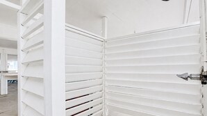 Een kamer met witte wanden en een douchekop aan het plafond.